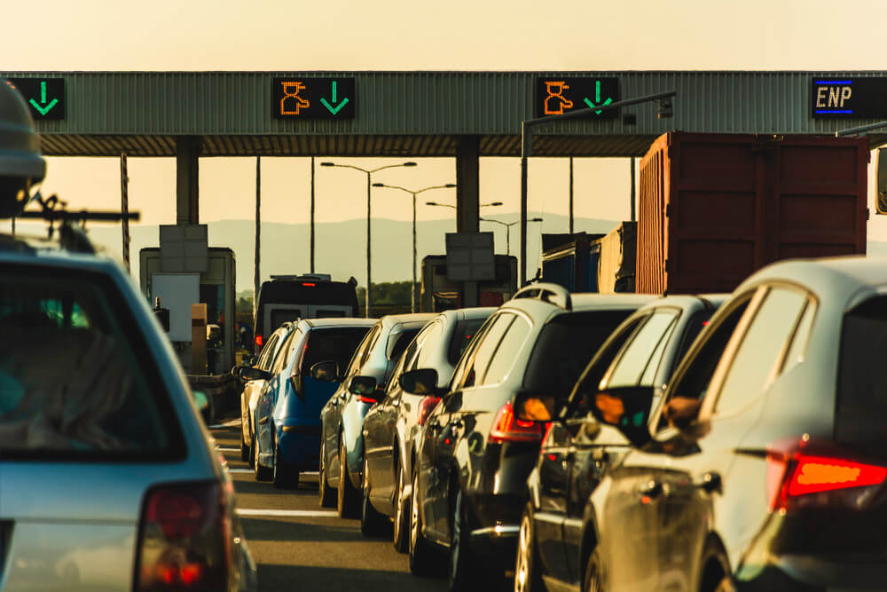 vehicles lining up at the queue of a toll road 