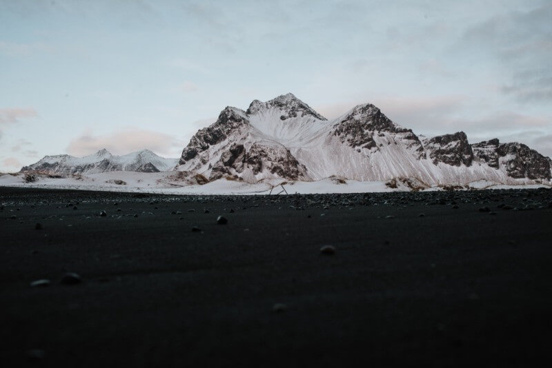 Impressive black sand beach with a mountain ridge towering over the background
